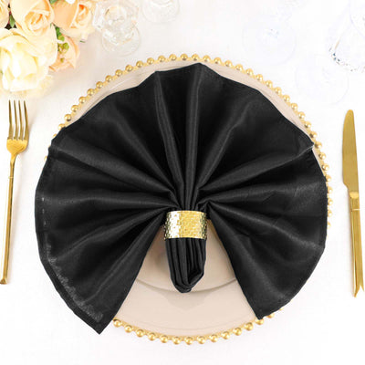 Elegant black napkin on a decorative plate with a gold holder.