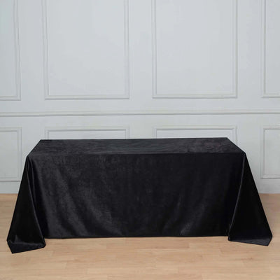 Black tablecloth draped over a table in a neutral setting.