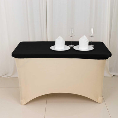 Black table cover with elegant napkin and glassware setup.