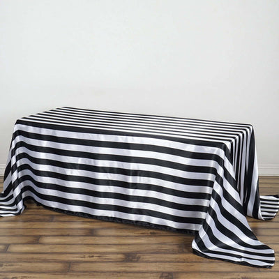 Black and white striped tablecloth draped on a wooden table.
