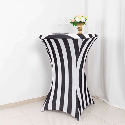 Black and white striped table cover with floral centerpiece and glasses.