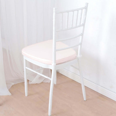 White wooden chair with a pink cushion, angled view.