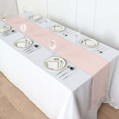 Elegant pink table runner on a white tablecloth with decorative plates and glassware.