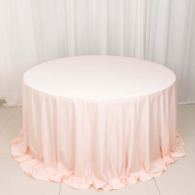 Round pink tablecloth with ruffled edges on a white table