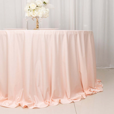 Peach tablecloth draping elegantly over a round table with floral centerpiece.