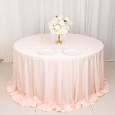 Pink round tablecloth draping over a table with a floral centerpiece.