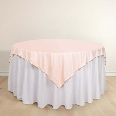 Round table with a pink and white tablecloth draped elegantly.