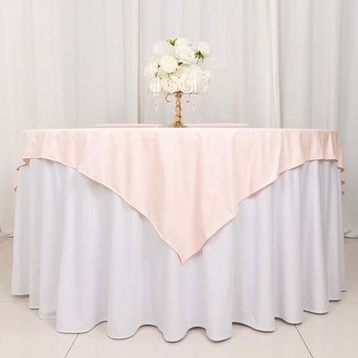 Elegant round table with a pink tablecloth and white floral centerpiece.
