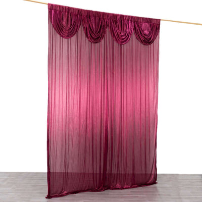 Sheer burgundy curtain with a gathered design hanging from a rod.