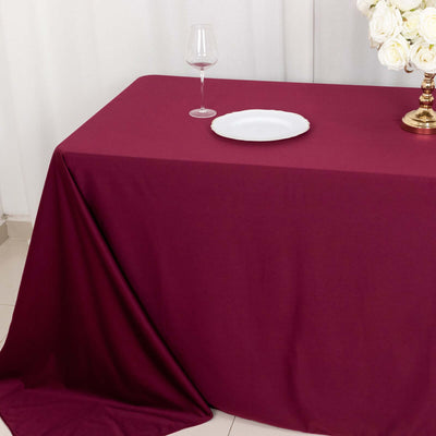 Burgundy tablecloth draped elegantly on a table with a wine glass and plate.