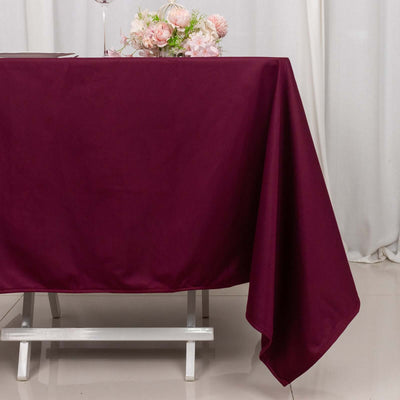 Burgundy tablecloth draped over a table with floral centerpiece.