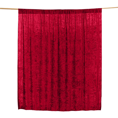 Red velvet curtain draped on a rod for elegant decor.