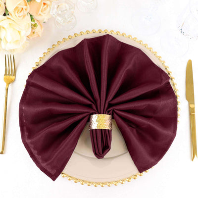 Elegant burgundy napkin arranged on a decorative plate with gold accents.