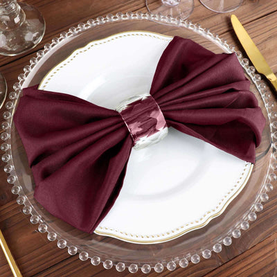 Burgundy napkin with silver ring on an elegant dinner plate