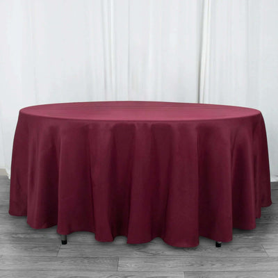 Round burgundy tablecloth on a wooden floor