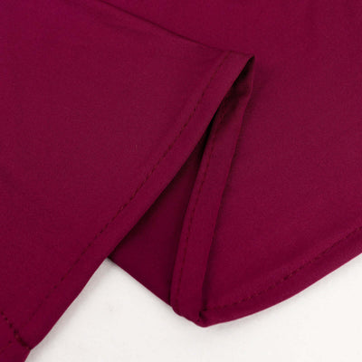 Close-up of burgundy fabric with detailed stitching.