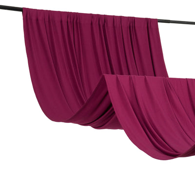 Burgundy drapery fabric hanging on a rod