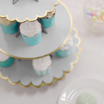 Tiered cupcake stand with decorated cupcakes and pastel colors.