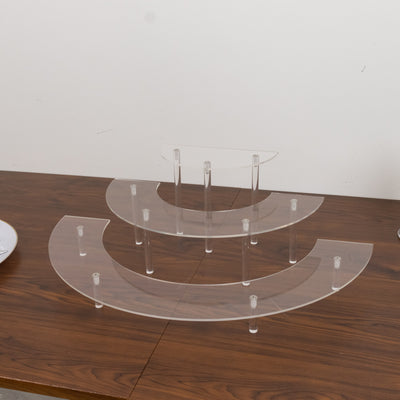 Acrylic display stand with three tiers on a wooden table.