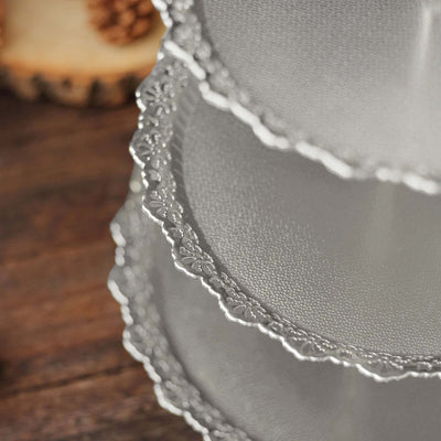 Decorative silver cake stand with intricate lace edge design.
