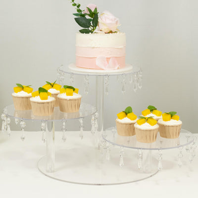 Elegant tiered dessert display with cupcakes and a cake topped with flowers.