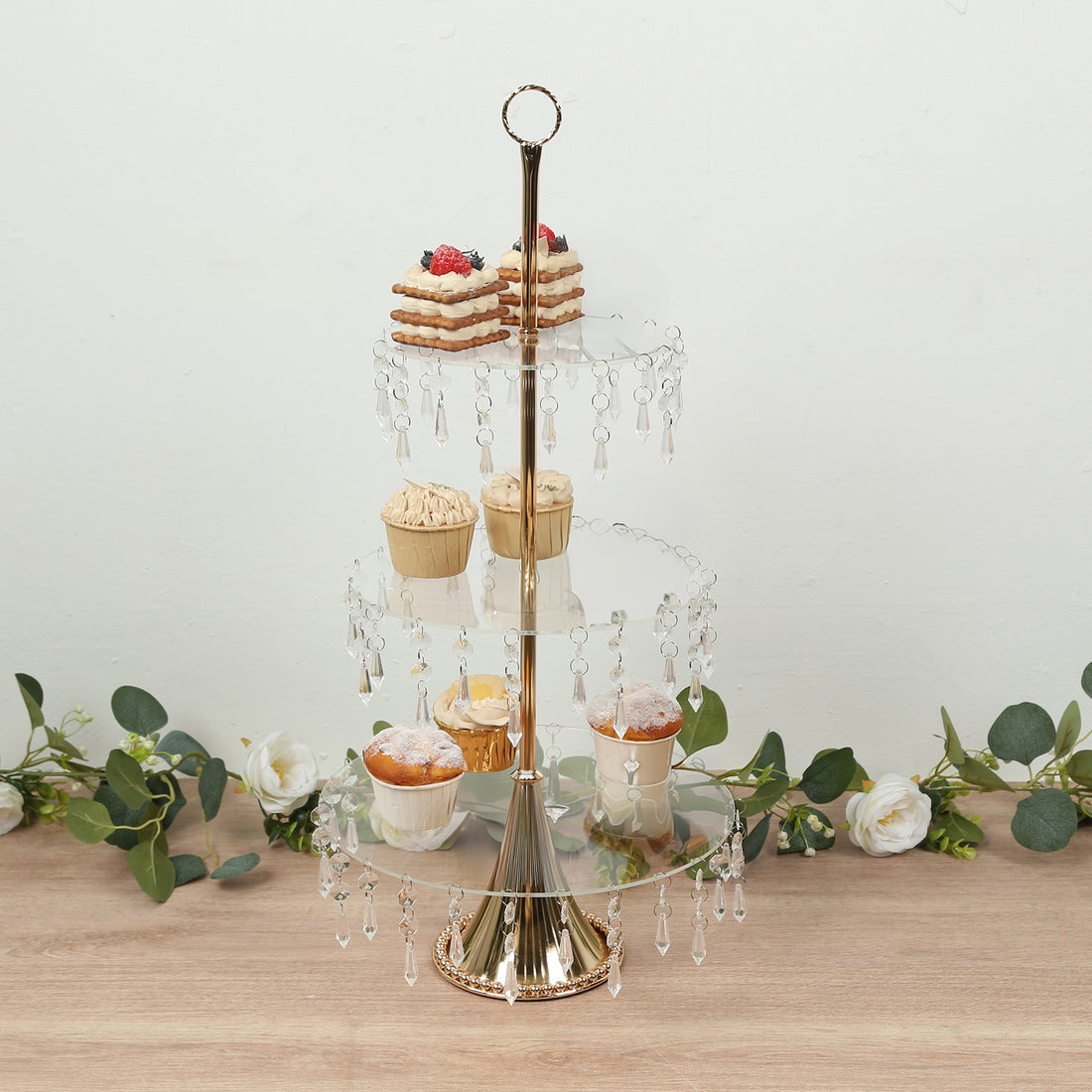 Elegant three-tiered dessert stand with crystal accents and assorted treats.