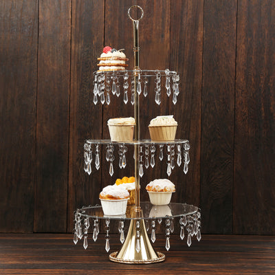 Three-tiered dessert stand with crystal accents, showcasing cupcakes and sweets.