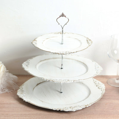 Three-tiered vintage white cake stand with ornate detailing.