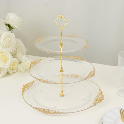 Three-tiered glass serving stand with gold accents and decorative edges.
