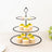 Three-tiered black cupcake stand with cupcakes and fruit decorations.