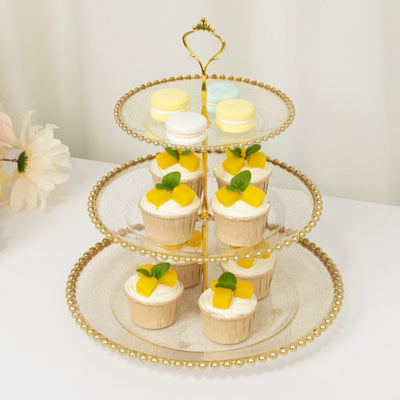 Three-tier dessert stand with cupcakes and macarons.