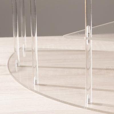 Transparent acrylic table legs on a wooden surface.
