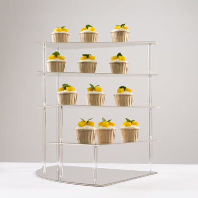 Cupcakes displayed on a stylish clear stand with lemon and mint garnish.