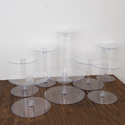 Clear acrylic display tables in various heights on a wooden surface.