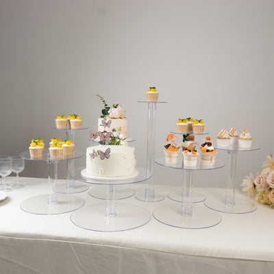 Dessert display with cupcakes and cake on clear acrylic stands.