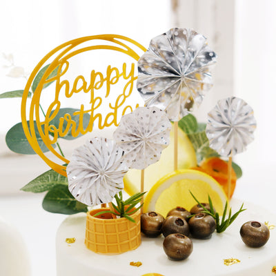 Birthday cake decorations with silver flowers and a "Happy Birthday" sign.