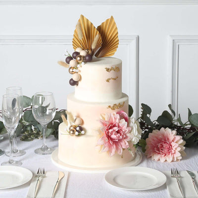 Elegant three-tiered wedding cake adorned with floral decorations and gold accents.