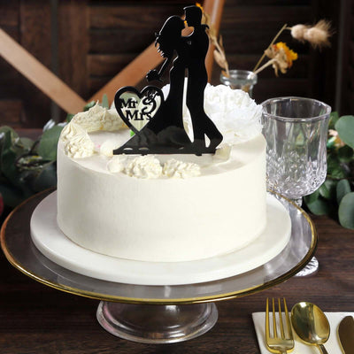 Wedding cake with elegant couple topper and floral decorations.