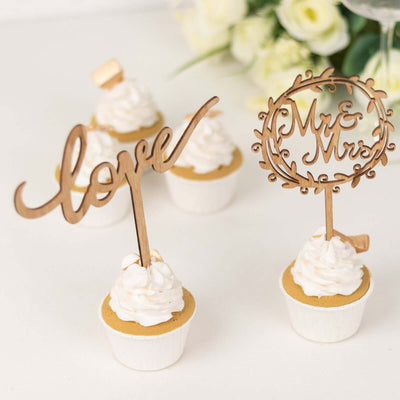 Wooden cake toppers "love" and "Mr & Mrs" on cupcakes.