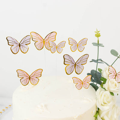 Gold and pink butterfly cake toppers on a white cake