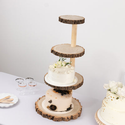 Four-tiered cake stand made of wood slices with decorative cakes and flowers.