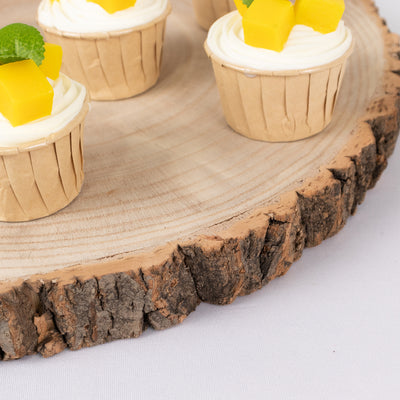 Mango cupcakes on a wooden platter with mint leaves.