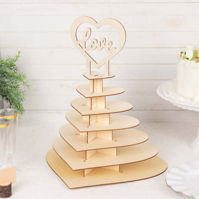 Wooden heart-shaped cake stand with 'love' topper for celebrations.