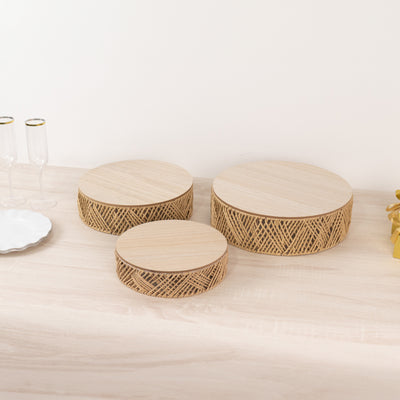 Three round wooden storage boxes with woven patterns.