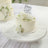 Birthday cake decorated with white roses on a cake stand.