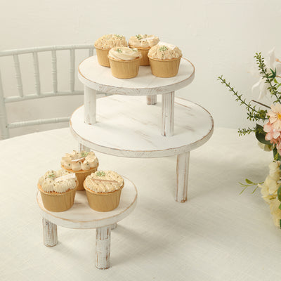 Wooden cupcake stand with frosted cupcakes arranged on three tiers.