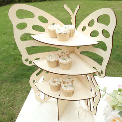 Butterfly-shaped cupcake stand with decorated cupcakes outdoors.
