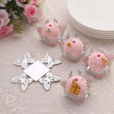 Pink decorative candles in butterfly holders on a lace tablecloth.
