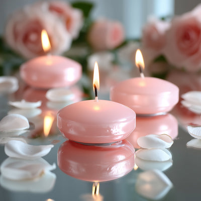 Pink floating candles surrounded by rose petals on a reflective surface.