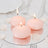 Pink floating candles on a mirrored surface with rose petals.